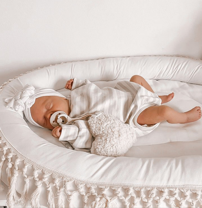 Newborn using heart plush charm as a dummy holder. Neutral textured soft plush charm.